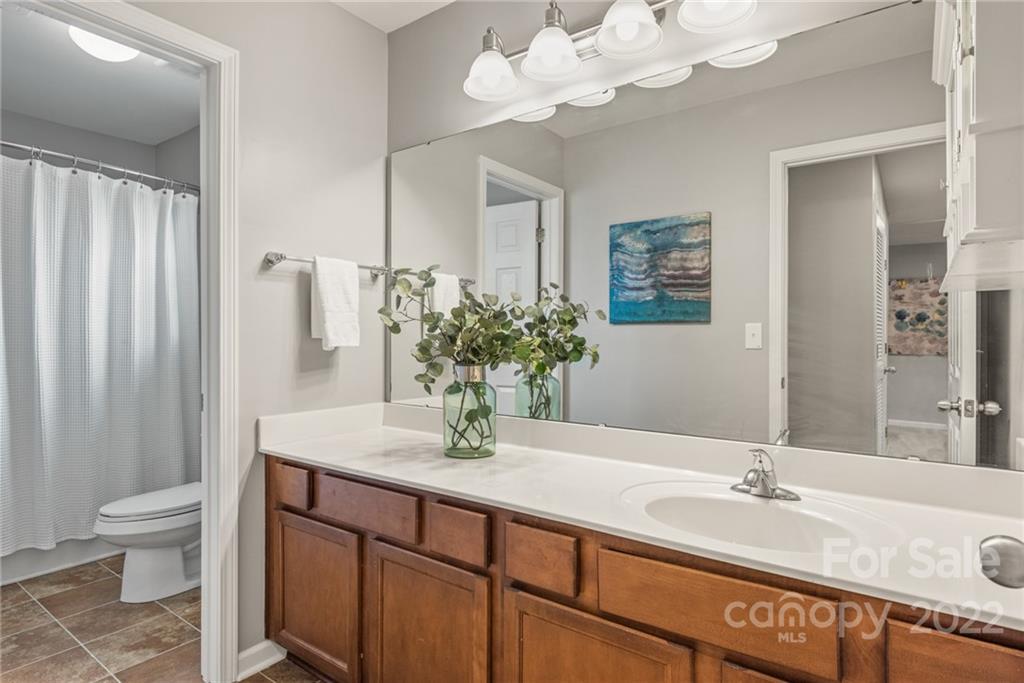 116 Annatto Way Tega Cay, SC 29708 - Photo 23 of 36 a bathroom with a granite countertop sink a toilet and a mirror