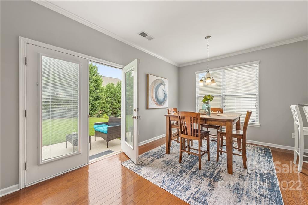 116 Annatto Way Tega Cay, SC 29708 - Photo 10 of 36 a dining room with wooden floor a chandelier a wooden table and chairs