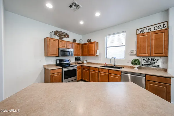 a large kitchen with stainless steel appliances granite countertop a stove sink and cabinets