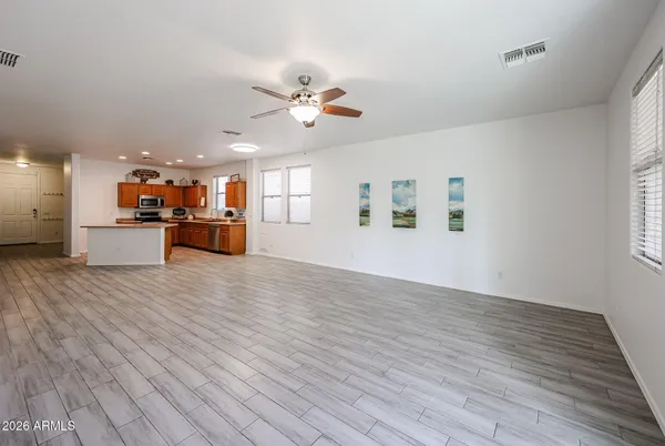 a view of a big room with wooden floor and windows