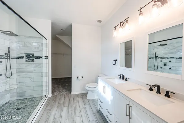 a bathroom with a double vanity sink mirror and shower