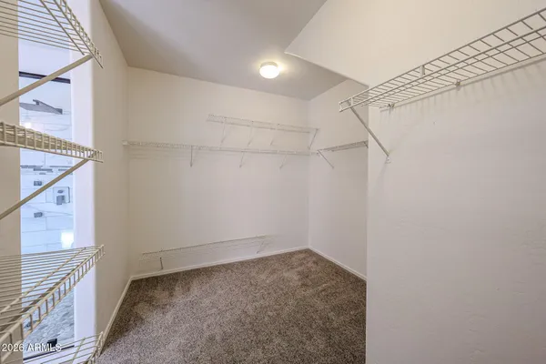 an empty room with windows and chandelier fan