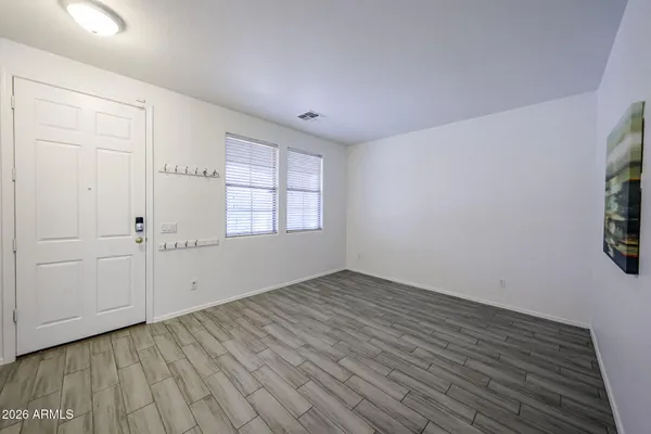 an empty room with wooden floor and windows