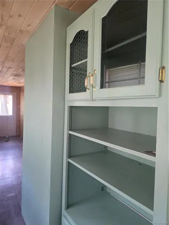 a view of an empty room with a fireplace and windows