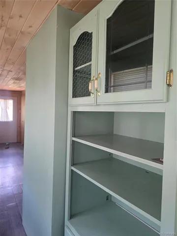 a view of an empty room with a fireplace and windows
