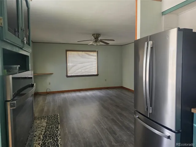 a view of a kitchen with a sink stove fridge and wooden floor