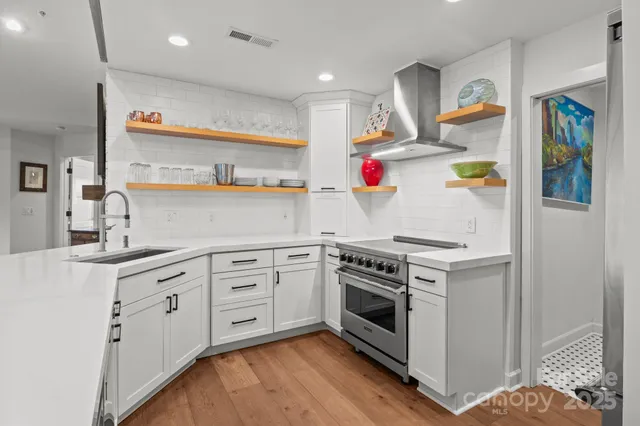 a kitchen with stainless steel appliances granite countertop a sink stove and refrigerator