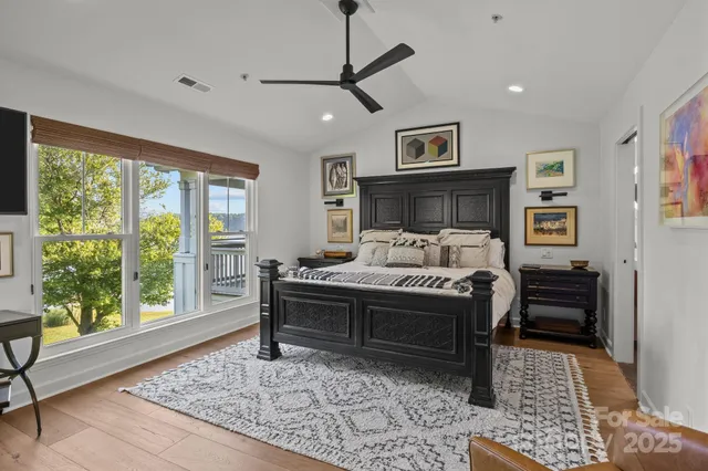 a bedroom with a bed a window and a flat screen tv