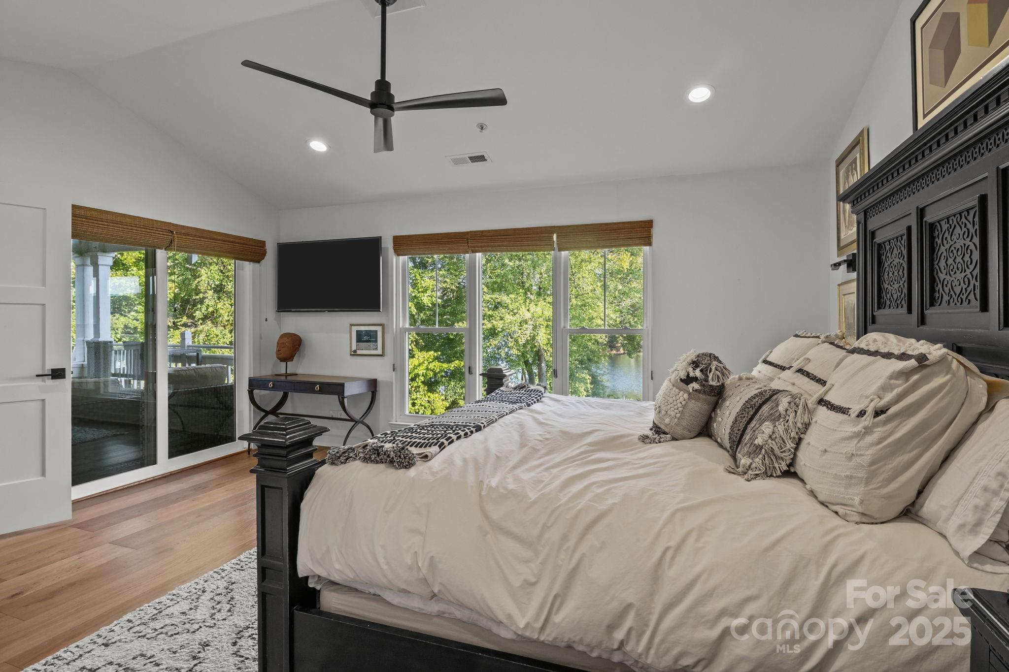 950 Jetton Street, Unit 3 Davidson, NC 28036 - Photo 22 of 29 a bedroom with a bed a window and a flat screen tv