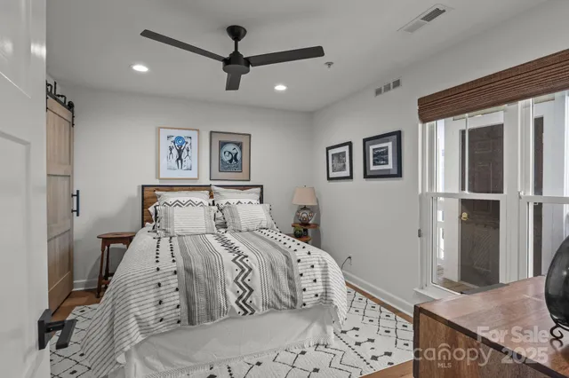 a bedroom with a large bed and a chandelier