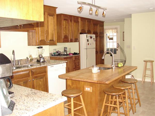 53 Wilder Road Sterling, MA 01564 - Photo 3 of 23 a kitchen with stainless steel appliances kitchen island granite countertop a table chairs and a refrigerator