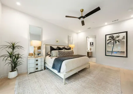 a spacious bedroom with a bed and a large window
