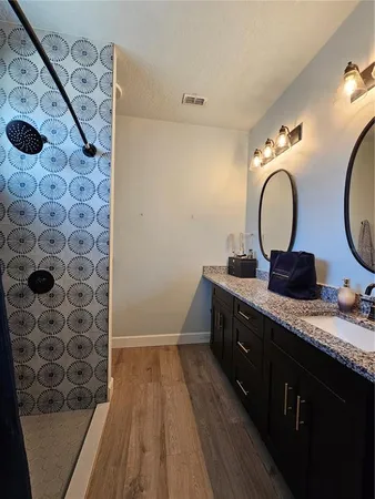 a bathroom with a double vanity sink mirror and shower