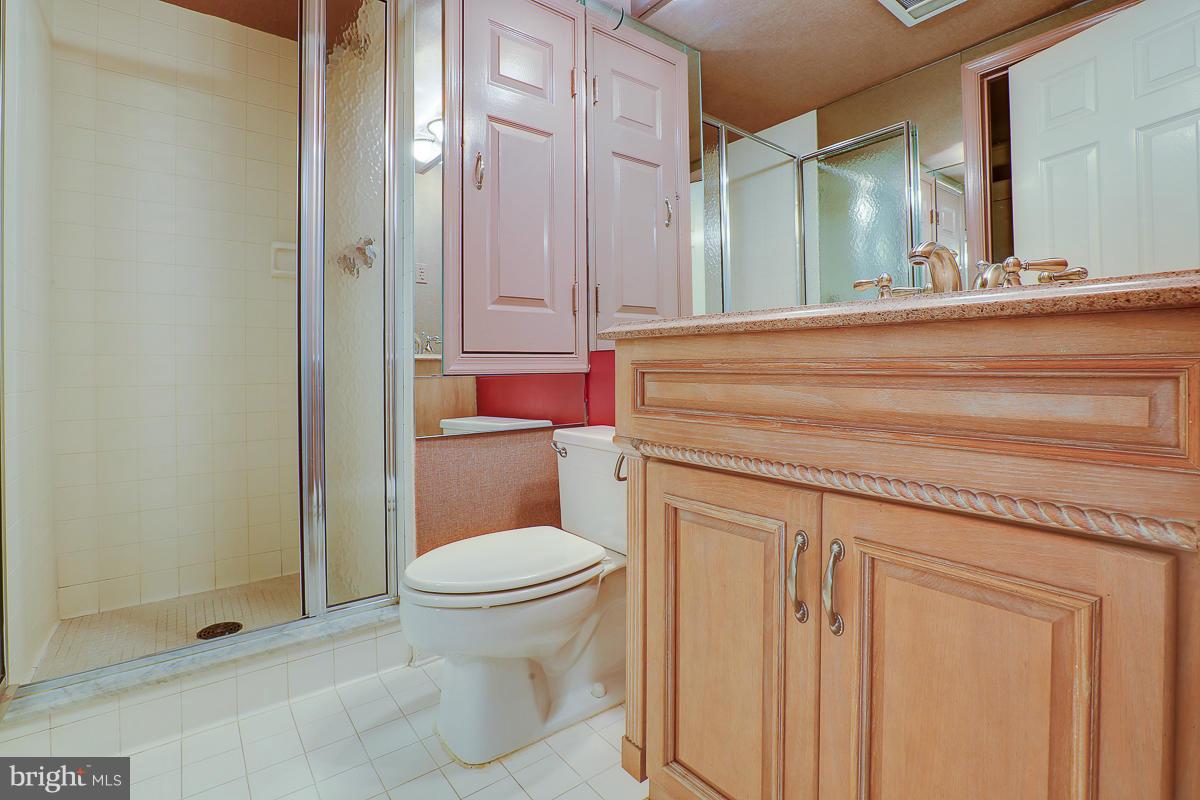 2331 Old Court Road, Unit 400 Baltimore, MD 21208 - Photo 9 of 27 a bathroom with a granite countertop sink a toilet and shower