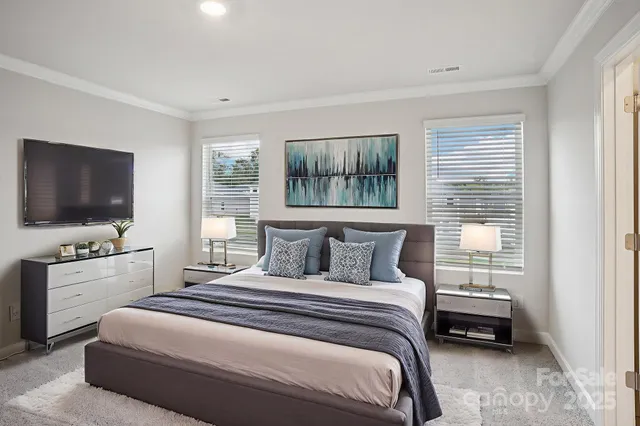 a bedroom with a bed and a flat tv screen on the dresser