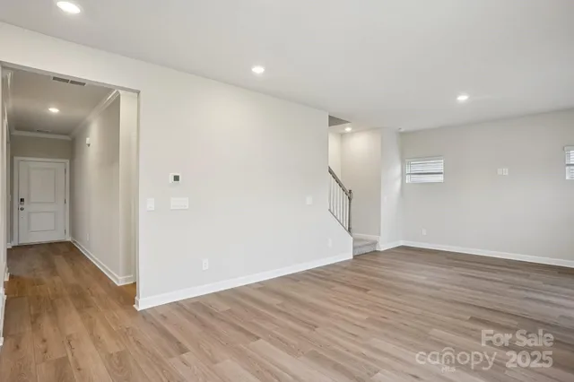 a view of empty room with wooden floor