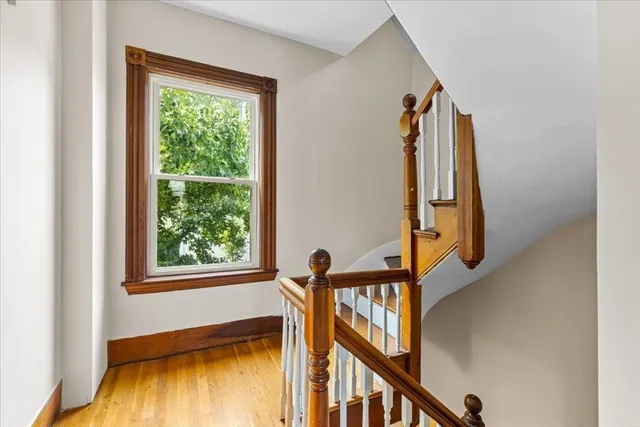 a view of a staircase with wooden floor and a window