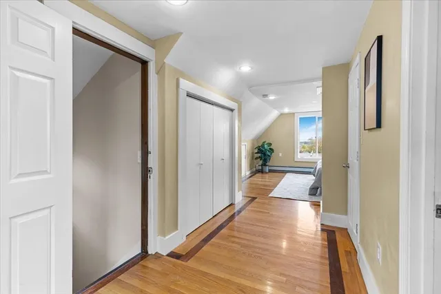 a view of a hallway with wooden floor and furniture in a bathroom