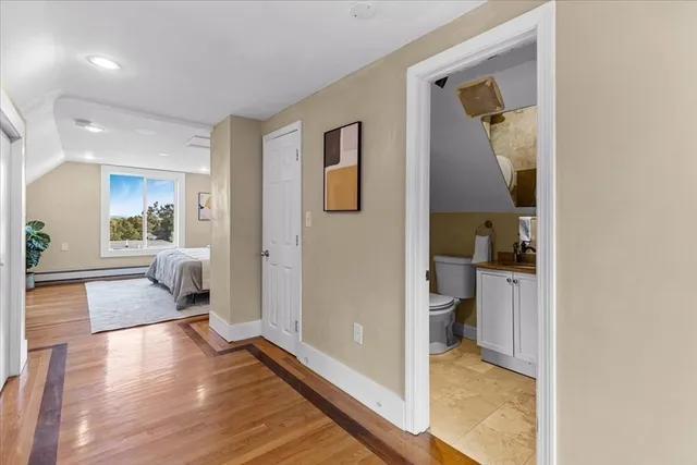 a view of a hallway with wooden floor windows and a livingroom