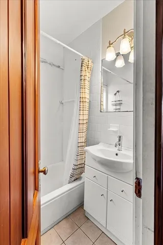 a bathroom with a tub a sink and mirror