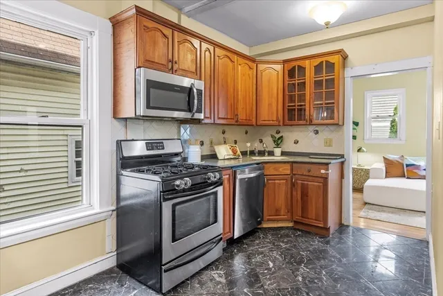 a kitchen with stainless steel appliances granite countertop a stove a sink and a microwave