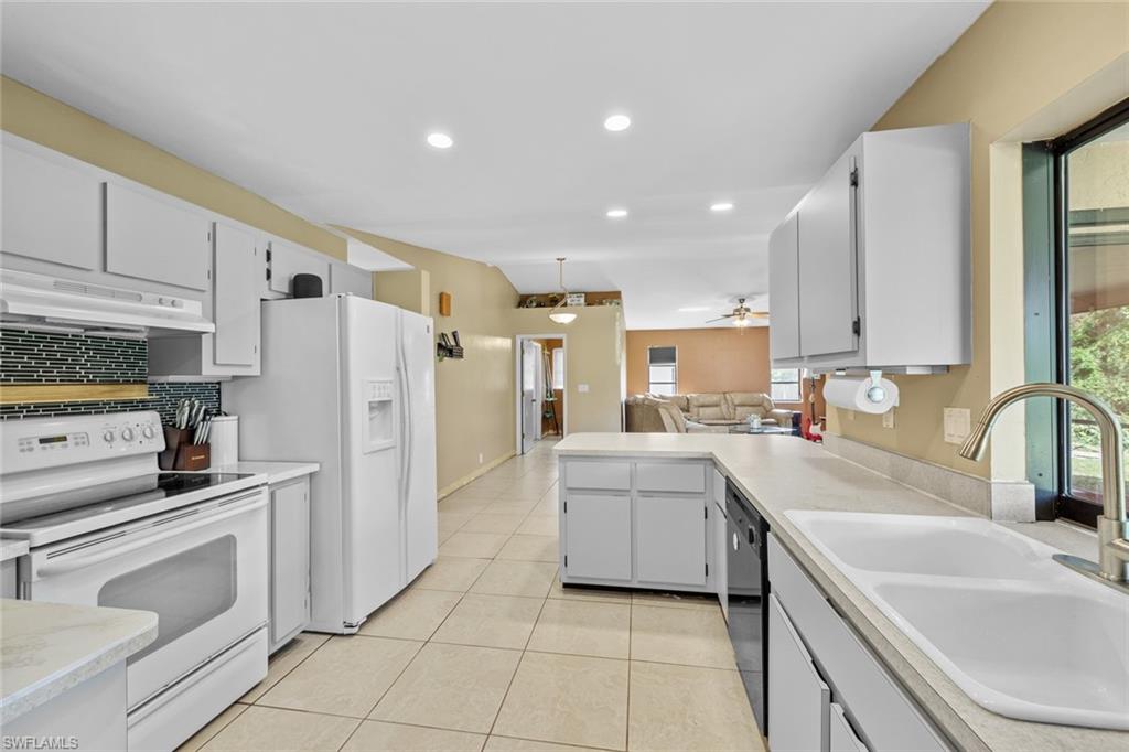 17452 Braddock Road Fort Myers, FL 33967 - Photo 4 of 38 Kitchen with sink, light tile patterned flooring, white cabinets, white appliances, and ceiling fan