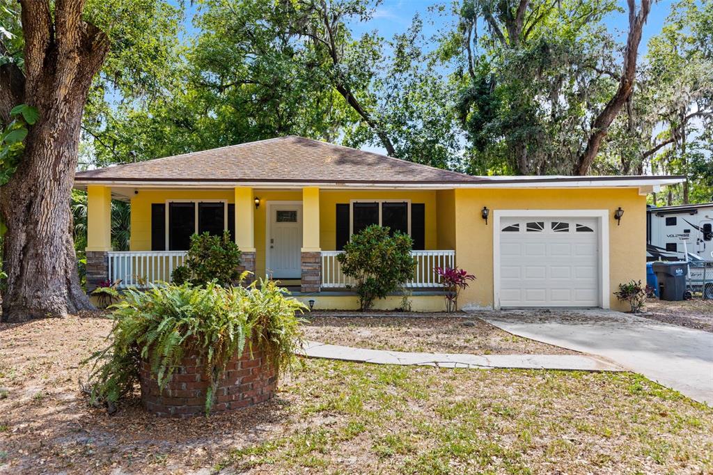 a view of a house with potted plants and large tree