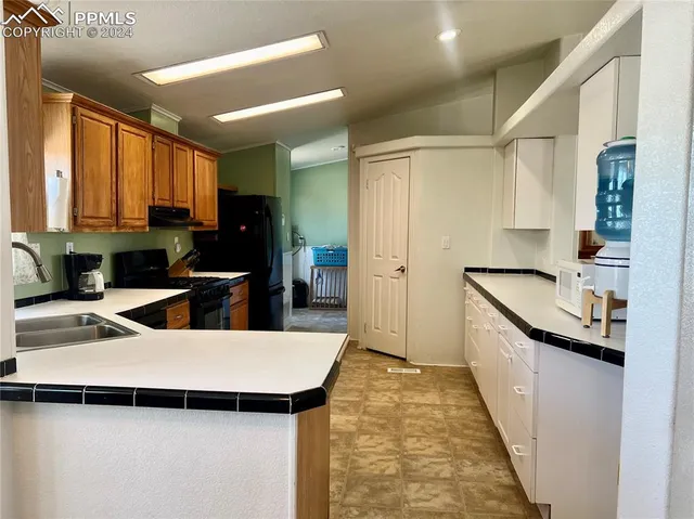 a kitchen with sink a refrigerator and cabinets
