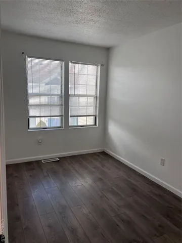 an empty room with wooden floor and white doors