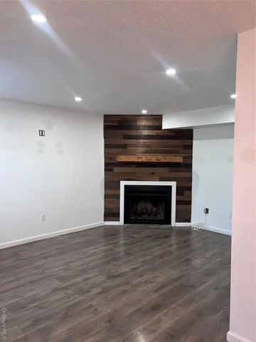 a view of empty room with wooden floor and fireplace