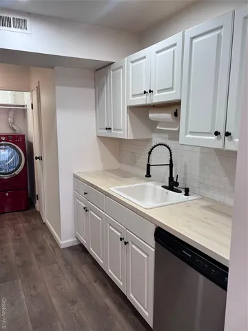 a kitchen with granite countertop a sink stove and cabinets