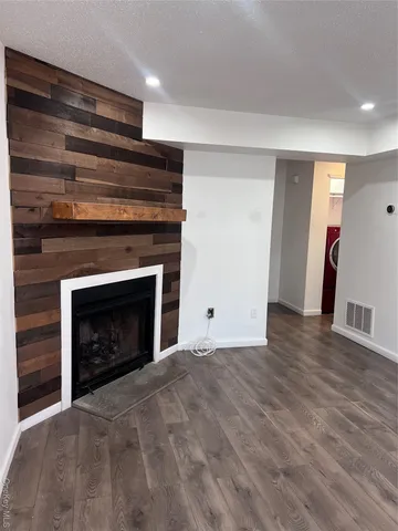 a view of empty room with wooden floor and fireplace