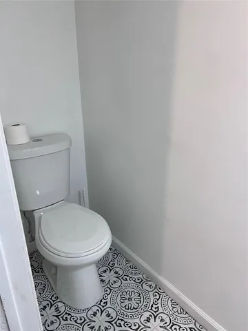a white toilet sitting next to a shower