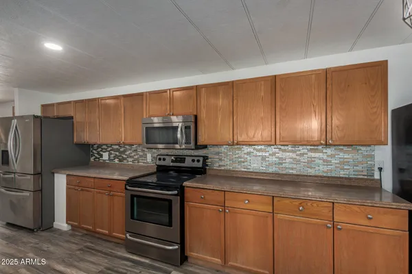 a kitchen with stainless steel appliances granite countertop a stove a refrigerator and a microwave