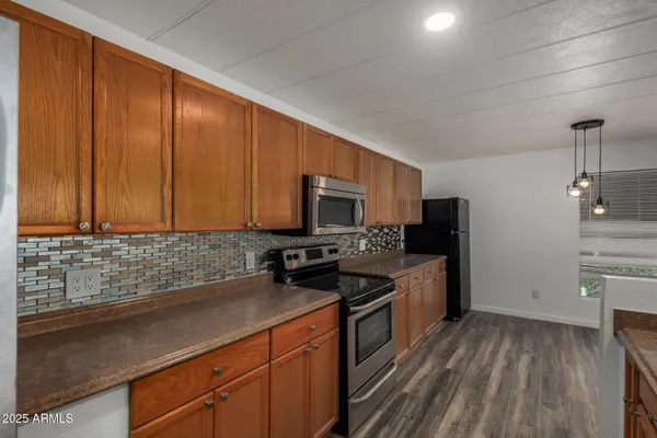 a kitchen with stainless steel appliances granite countertop a sink stove and refrigerator