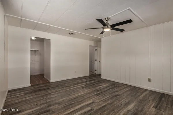 a view of a big room with wooden floor and a ceiling fan