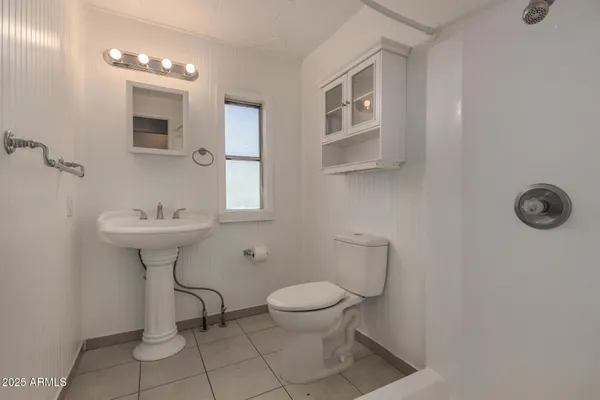 a bathroom with a sink a toilet and a mirror