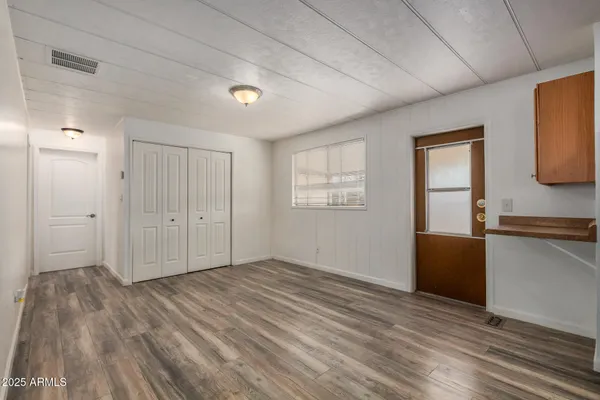 a view of an empty room with window and wooden floor