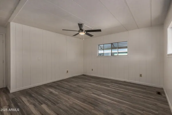 a view of a room with wooden floor and a ceiling fan