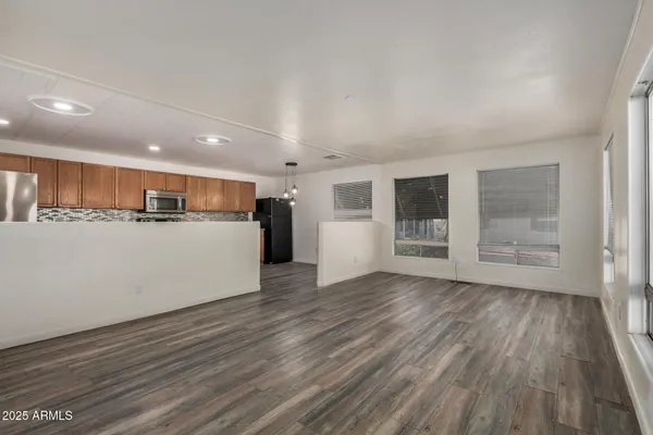 a view of a kitchen with a sink and dishwasher with wooden floor