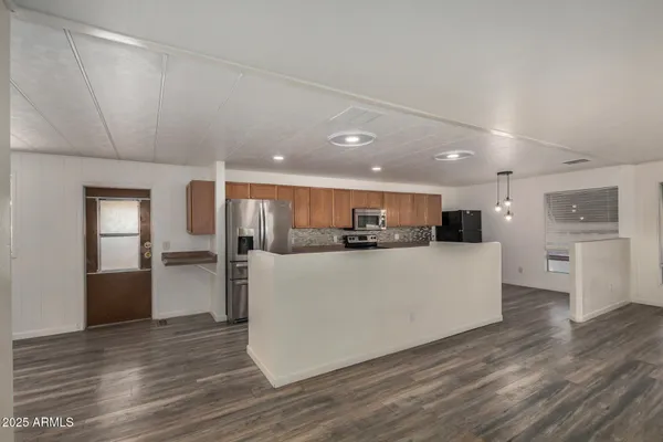 a view of kitchen with stainless steel appliances granite countertop a refrigerator and a stove top oven