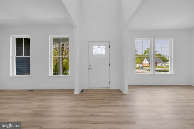 an empty room with window & wooden floor
