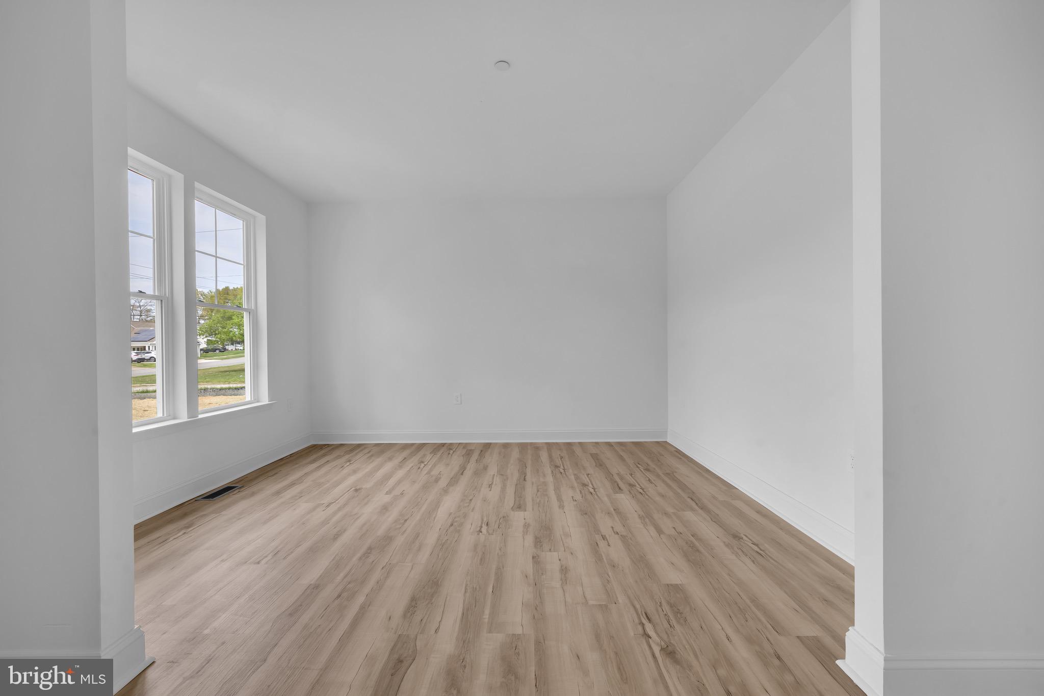 415 Trimble Road Joppa, MD 21085 - Photo 5 of 14 an empty room with wooden floor and windows