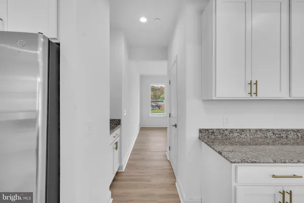 a view of an empty room with wooden floor and closet