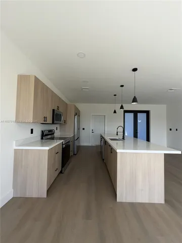 a kitchen with stainless steel appliances a stove top oven a sink a counter top space and cabinets