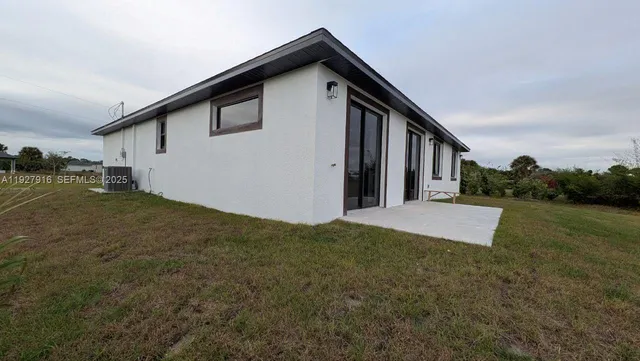a view of a house with backyard and trees