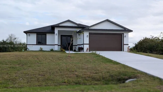 a front view of a house with a yard and garage
