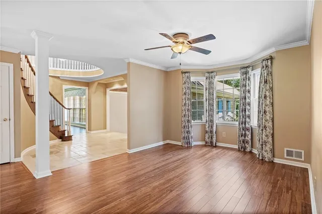 a view of a livingroom with wooden floor a fireplace and windows