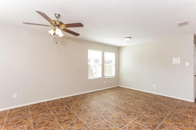 a view of a big room with a ceiling fan and a window