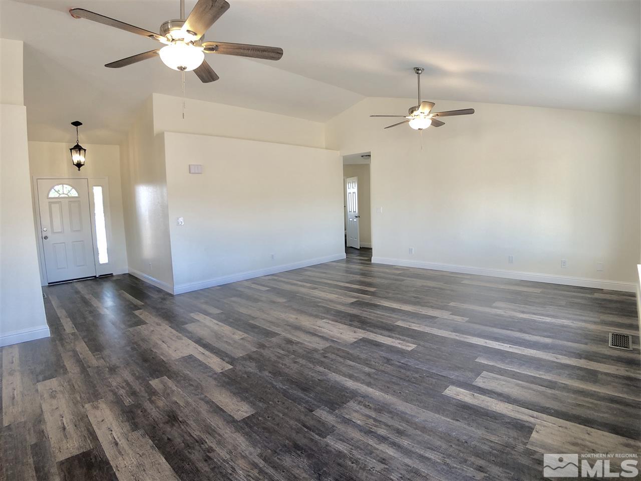 10205 Placerville Road Reno, NV 89508 - Photo 14 of 40 a view of an empty room with chandelier fan and a fireplace